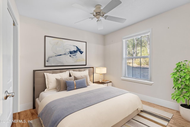 bedroom with ceiling fan, light hardwood / wood-style flooring, and a closet