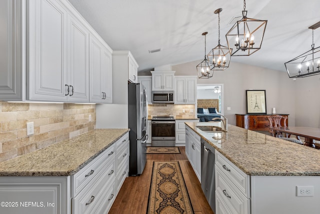 kitchen featuring an island with sink, appliances with stainless steel finishes, white cabinets, and pendant lighting