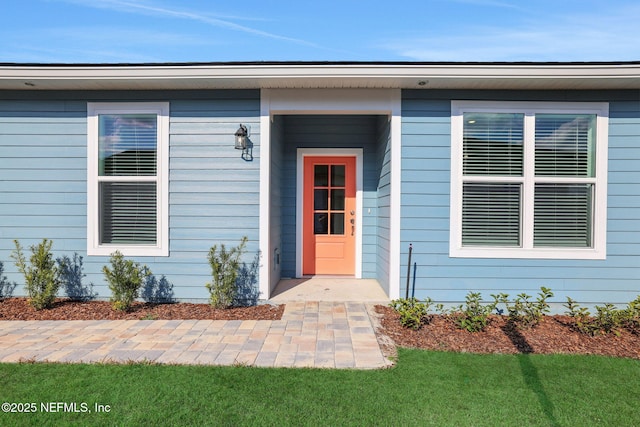 doorway to property featuring a lawn