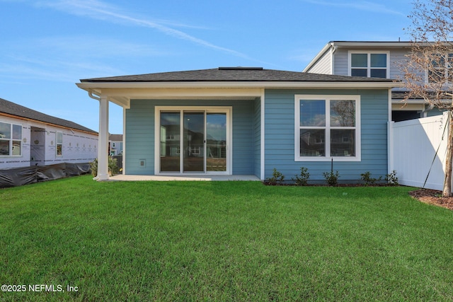 back of house featuring a patio area and a lawn