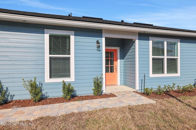 entrance to property with a lawn