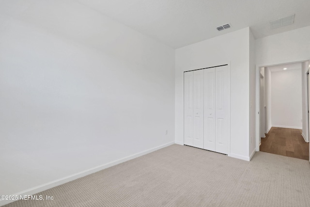 unfurnished bedroom featuring a closet and light carpet