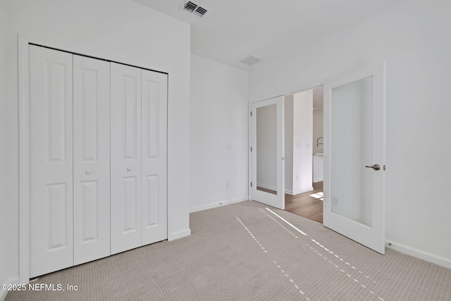 unfurnished bedroom featuring carpet flooring and a closet