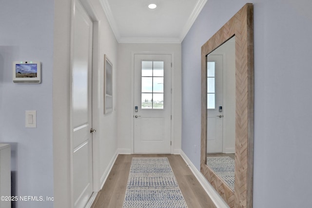 entryway with ornamental molding and light hardwood / wood-style flooring