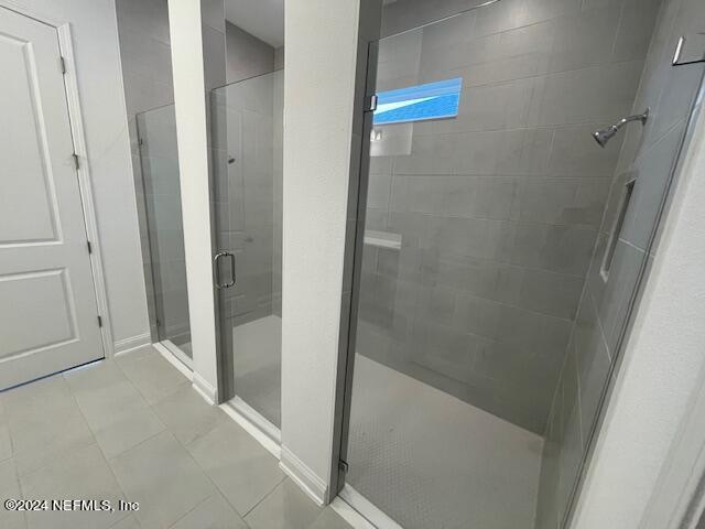 bathroom with walk in shower and tile patterned floors