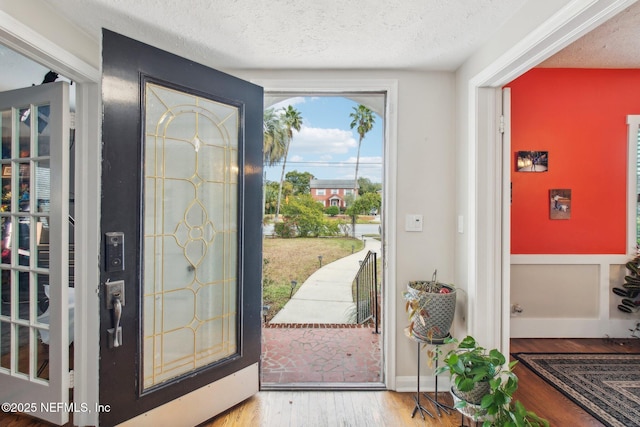 foyer entrance with a textured ceiling and hardwood / wood-style floors