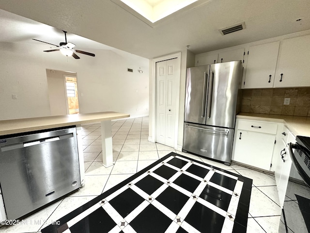 kitchen with ceiling fan, white cabinets, appliances with stainless steel finishes, and tasteful backsplash