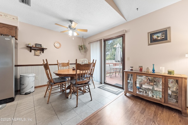 tiled dining room featuring a textured ceiling and ceiling fan