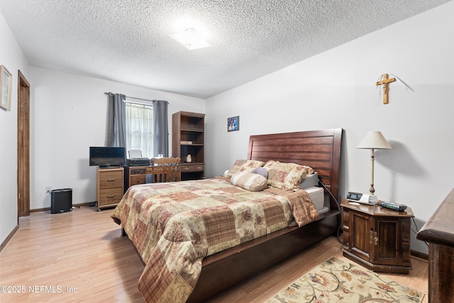 bedroom with a textured ceiling and light hardwood / wood-style flooring