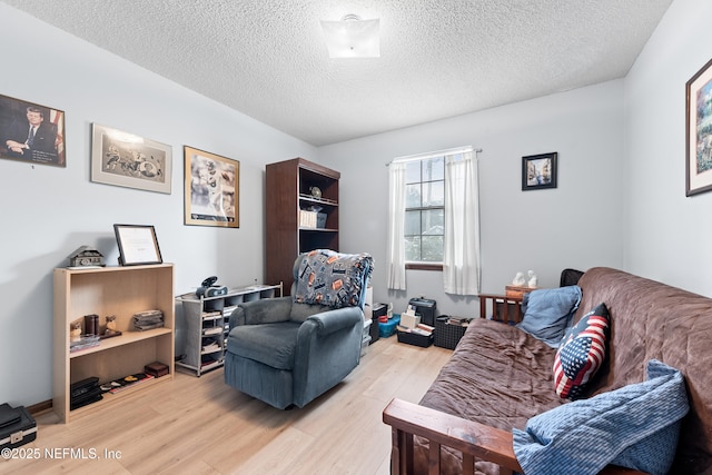 living room with light hardwood / wood-style floors and a textured ceiling