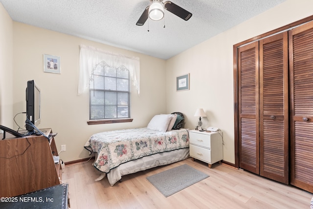 bedroom featuring ceiling fan, a closet, a textured ceiling, and light hardwood / wood-style floors