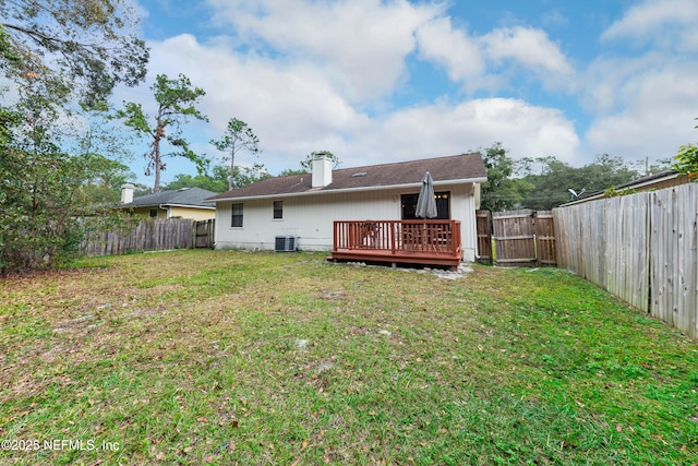 rear view of property featuring a wooden deck, central air condition unit, and a yard