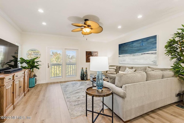 living room with crown molding, ceiling fan, and light hardwood / wood-style flooring