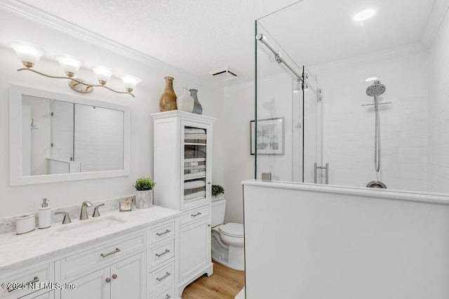 bathroom featuring hardwood / wood-style floors, toilet, vanity, walk in shower, and crown molding