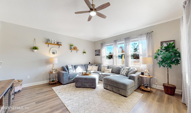 living room with hardwood / wood-style flooring, a textured ceiling, and ceiling fan