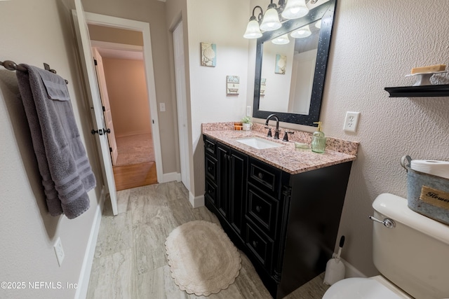 bathroom with hardwood / wood-style floors, toilet, and vanity