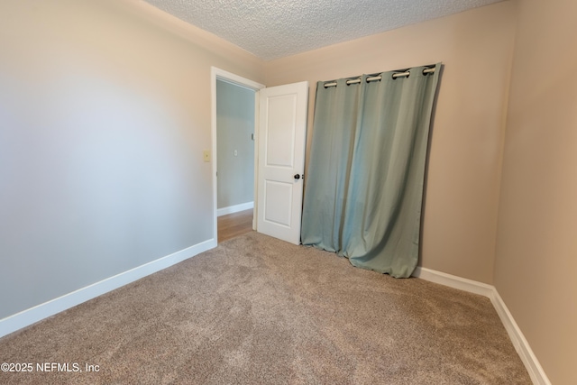 unfurnished room featuring light carpet and a textured ceiling