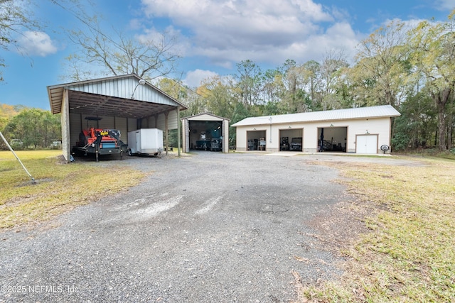 view of outdoor structure featuring a garage, a yard, and a carport