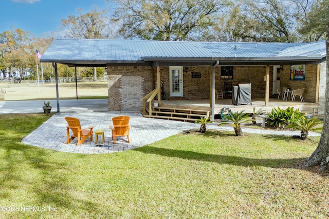 back of house with a deck, a yard, and a patio