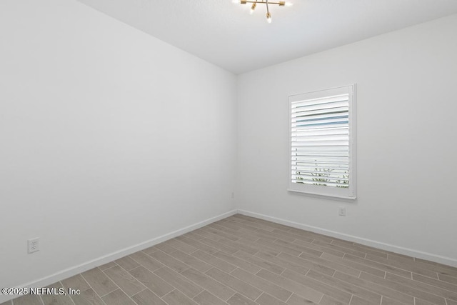 unfurnished room featuring an inviting chandelier