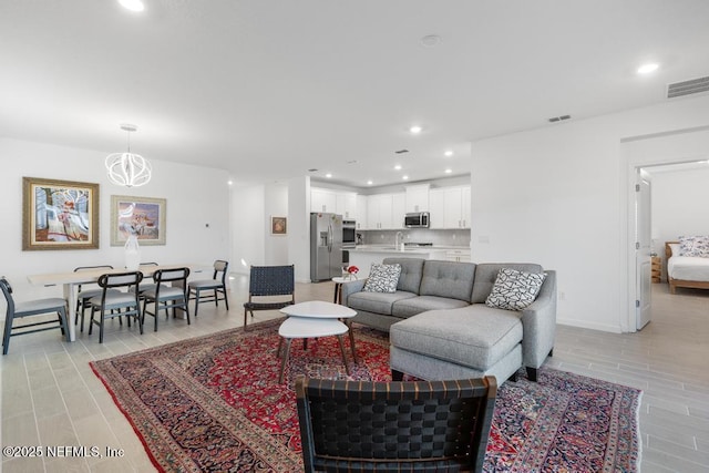 living room with an inviting chandelier and sink