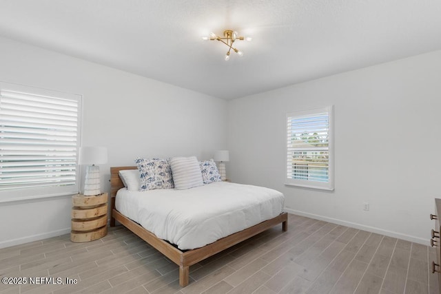 bedroom featuring a notable chandelier and light hardwood / wood-style flooring