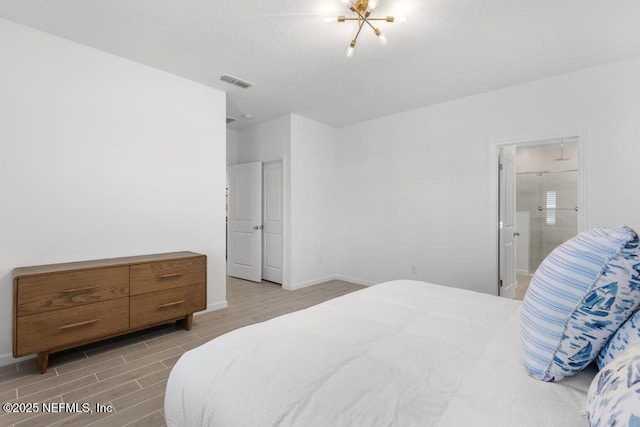 bedroom featuring ensuite bath and an inviting chandelier