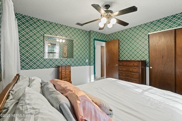 bedroom featuring ceiling fan, a closet, and a textured ceiling