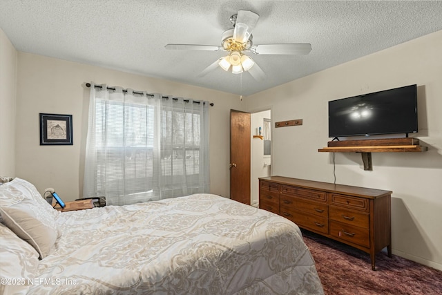 carpeted bedroom featuring ceiling fan and a textured ceiling