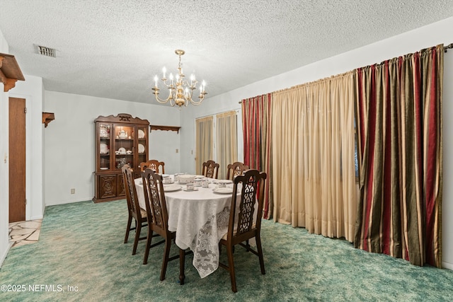 dining space with carpet, a notable chandelier, and a textured ceiling