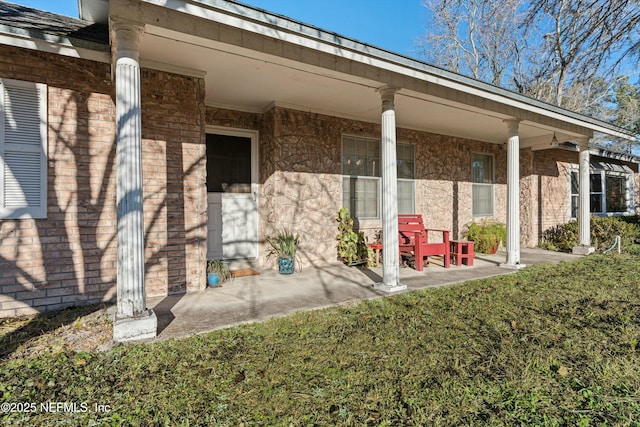 property entrance featuring a lawn and a porch