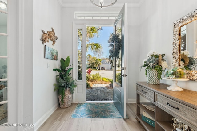 foyer with light hardwood / wood-style flooring and crown molding