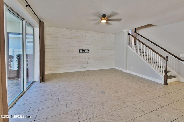 spare room featuring a textured ceiling, ceiling fan, and plenty of natural light