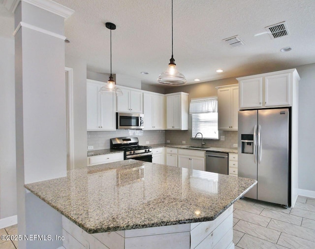 kitchen featuring white cabinets, stainless steel appliances, sink, and pendant lighting