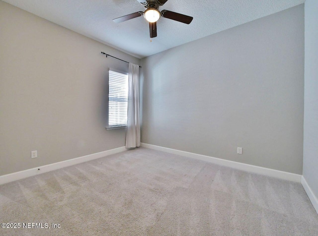 spare room featuring light colored carpet, ceiling fan, and a textured ceiling