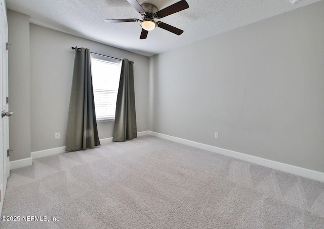 unfurnished room with a textured ceiling, ceiling fan, and light colored carpet