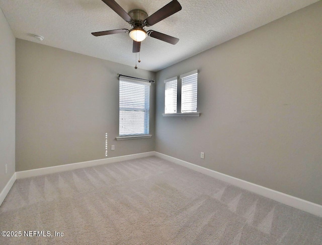 carpeted spare room featuring a textured ceiling and ceiling fan