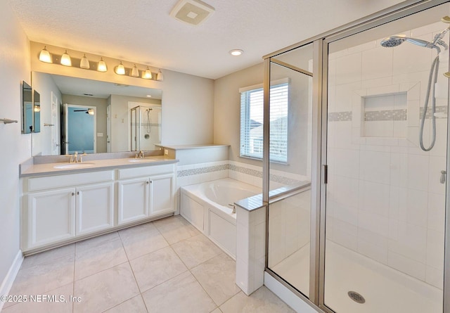 bathroom with a textured ceiling, vanity, separate shower and tub, and tile patterned floors