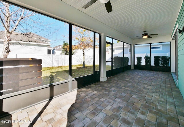 unfurnished sunroom with ceiling fan