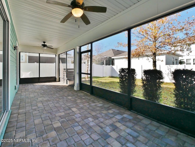 unfurnished sunroom with ceiling fan