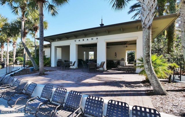 back of property featuring ceiling fan and a patio