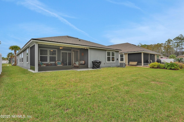 back of property with central AC unit, a yard, and a sunroom