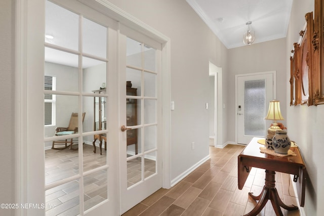 hallway with ornamental molding and french doors