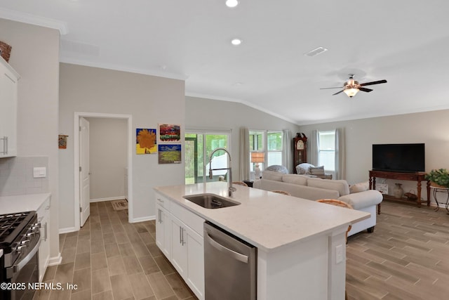 kitchen with a center island with sink, range with gas stovetop, white cabinets, stainless steel dishwasher, and sink