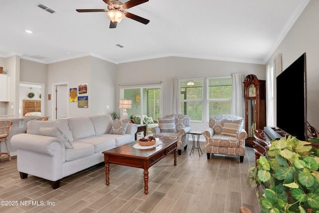 living room with ceiling fan, ornamental molding, and lofted ceiling