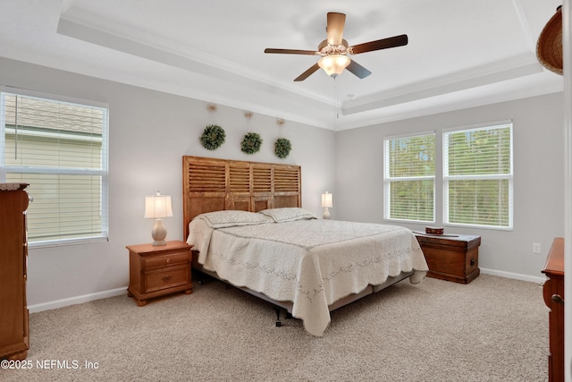 carpeted bedroom featuring a raised ceiling, ceiling fan, and crown molding