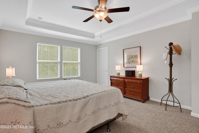 bedroom featuring a tray ceiling, light carpet, ornamental molding, and ceiling fan