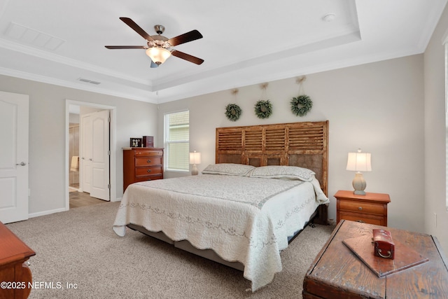 bedroom featuring crown molding, a tray ceiling, carpet floors, and ceiling fan