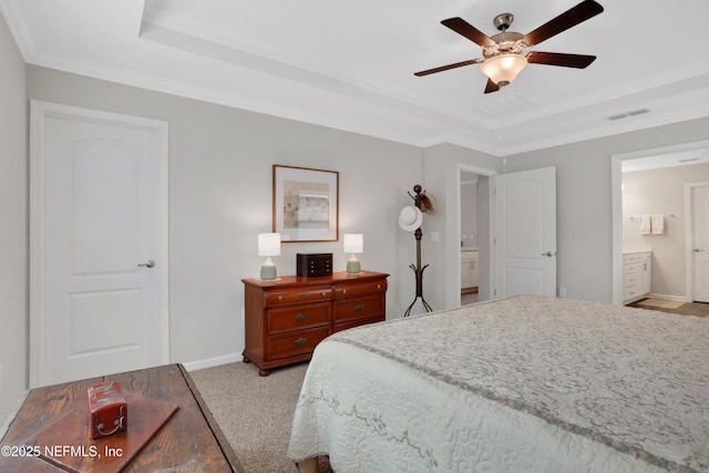 bedroom featuring ensuite bath, ceiling fan, light carpet, a tray ceiling, and ornamental molding