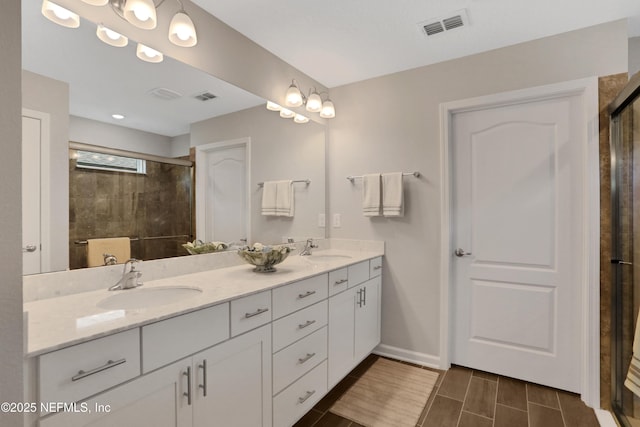 bathroom with a shower with door and vanity